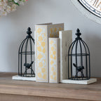 Decorative bookends with birdcage design on a wooden surface.