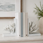 Cove Coral Bookends 2 Piece in white holding a selection of neutral books on a console table.
