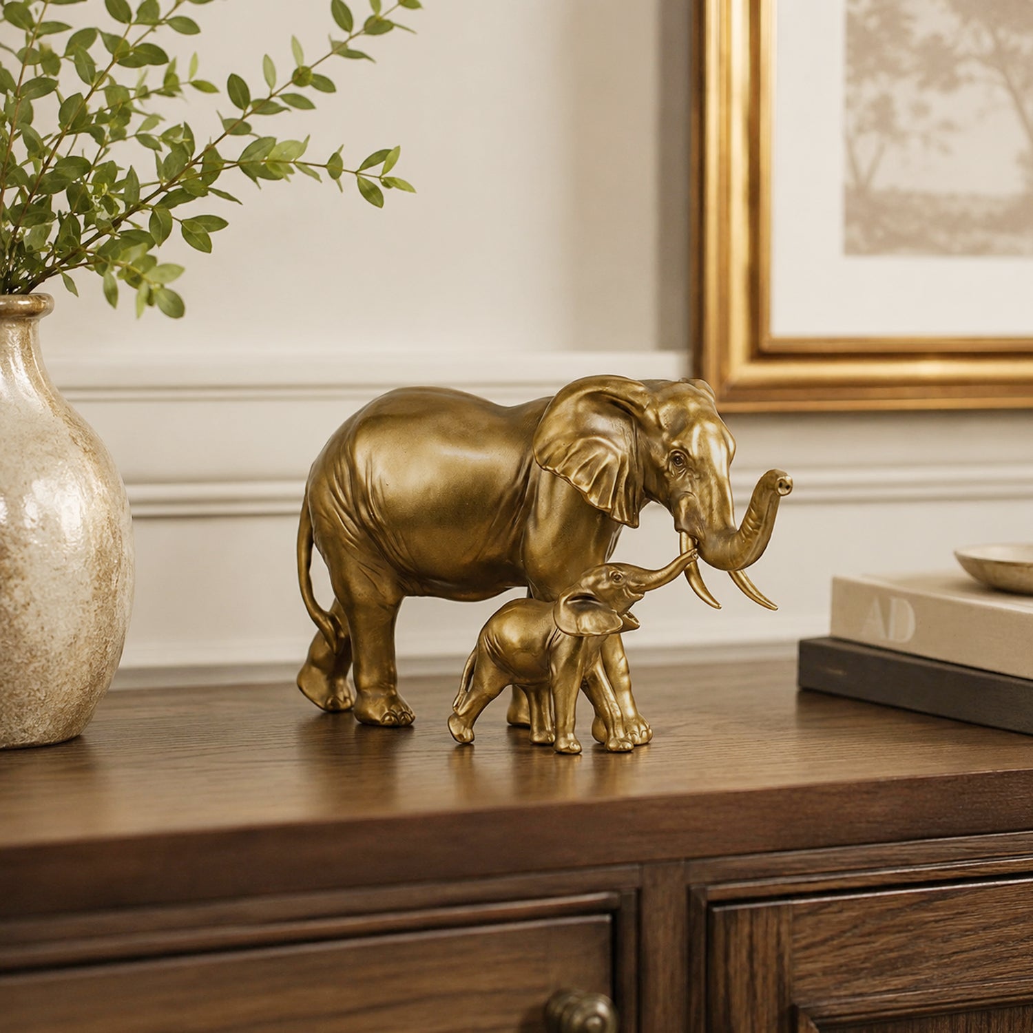 Design Republique Elephant Statue in gold featuring an adult elephant and calf displayed on a wooden sideboard.
