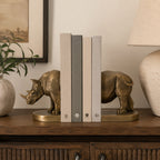 Design Republique Rhino Bronze Bookends 2 Piece Set styled on a wooden console with books between the bronze rhino design.