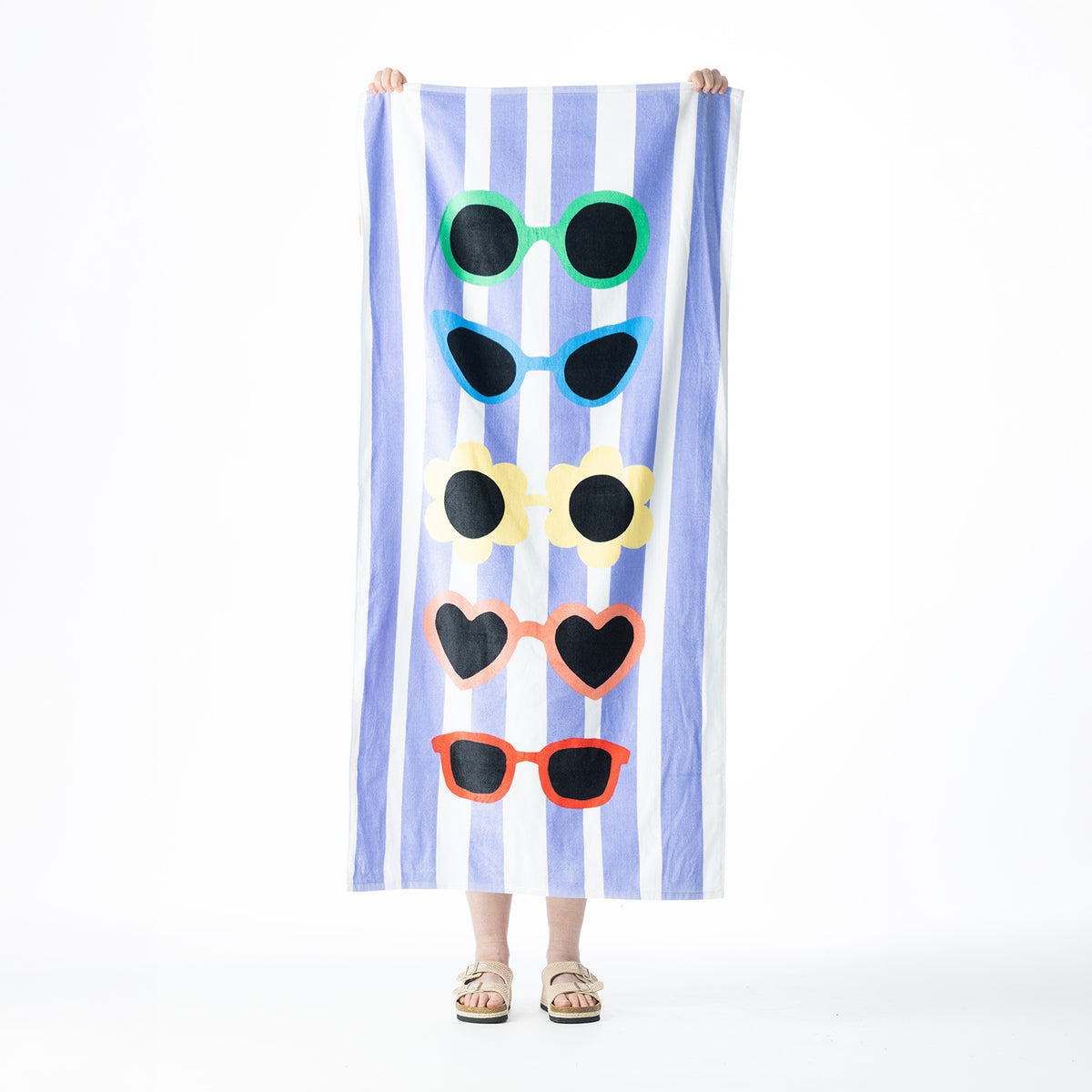 Blue and white striped Seaside Supplies beach towel featuring five colourful sunglasses designs, held up against a white background.