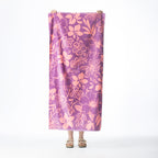 Purple Seaside Supplies beach towel featuring an all-over pink hibiscus floral print, held up against a white background.