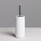 A sleek white toilet brush with a minimalist cylindrical holder and brushed stainless steel handle adds clean, contemporary style to any bathroom.
