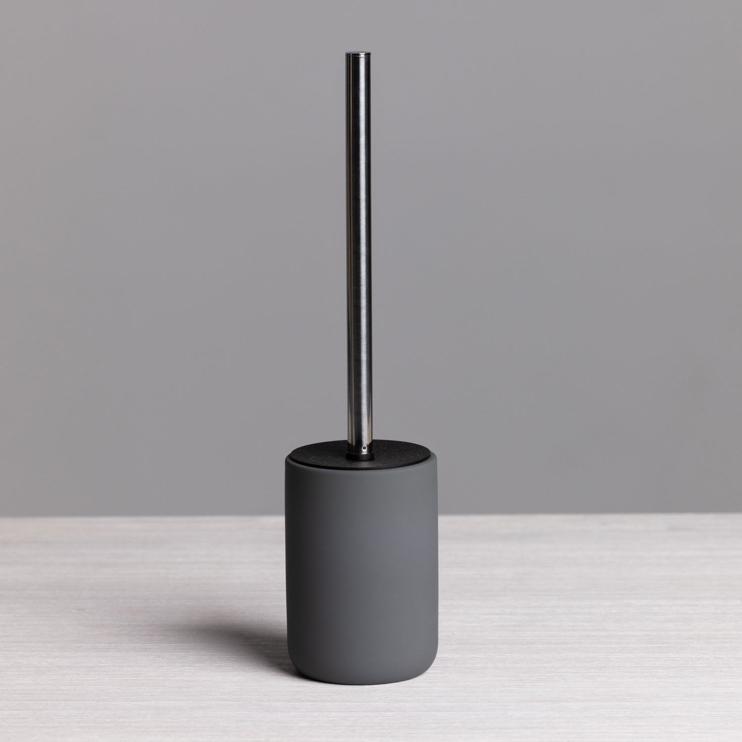A modern charcoal toilet brush with a minimalist cylindrical holder and brushed stainless steel handle brings sleek, contemporary style to any bathroom.