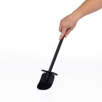 A hand holding a long-handled cleaning toilet brush with a black textured scrubber head and a black handle, shown against a plain white background.