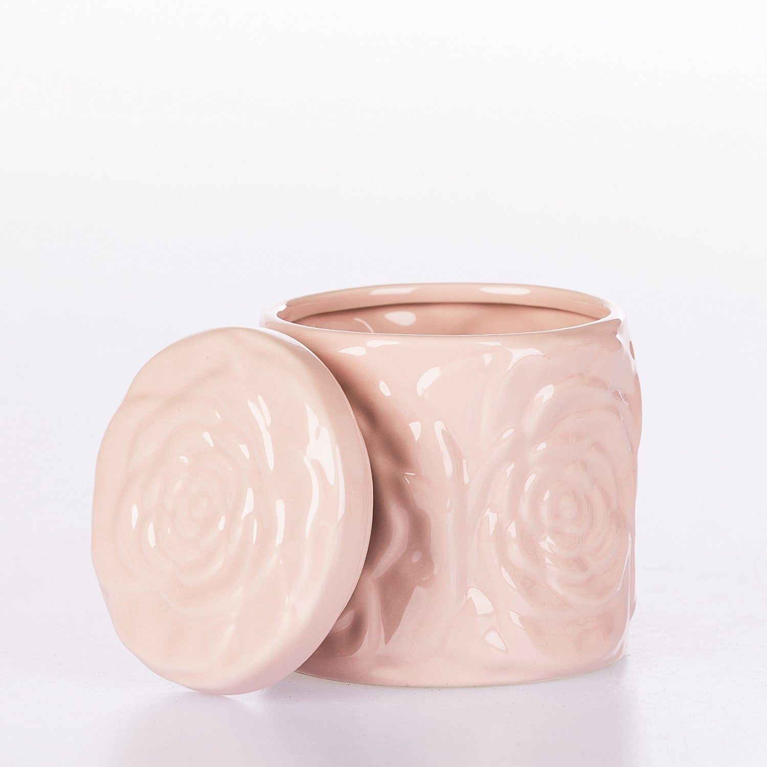 Pink ceramic jar with lid on a light gray background