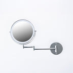 Solace Gigi LED wall-mounted round magnifying mirror in a polished silver finish with an adjustable swing arm.