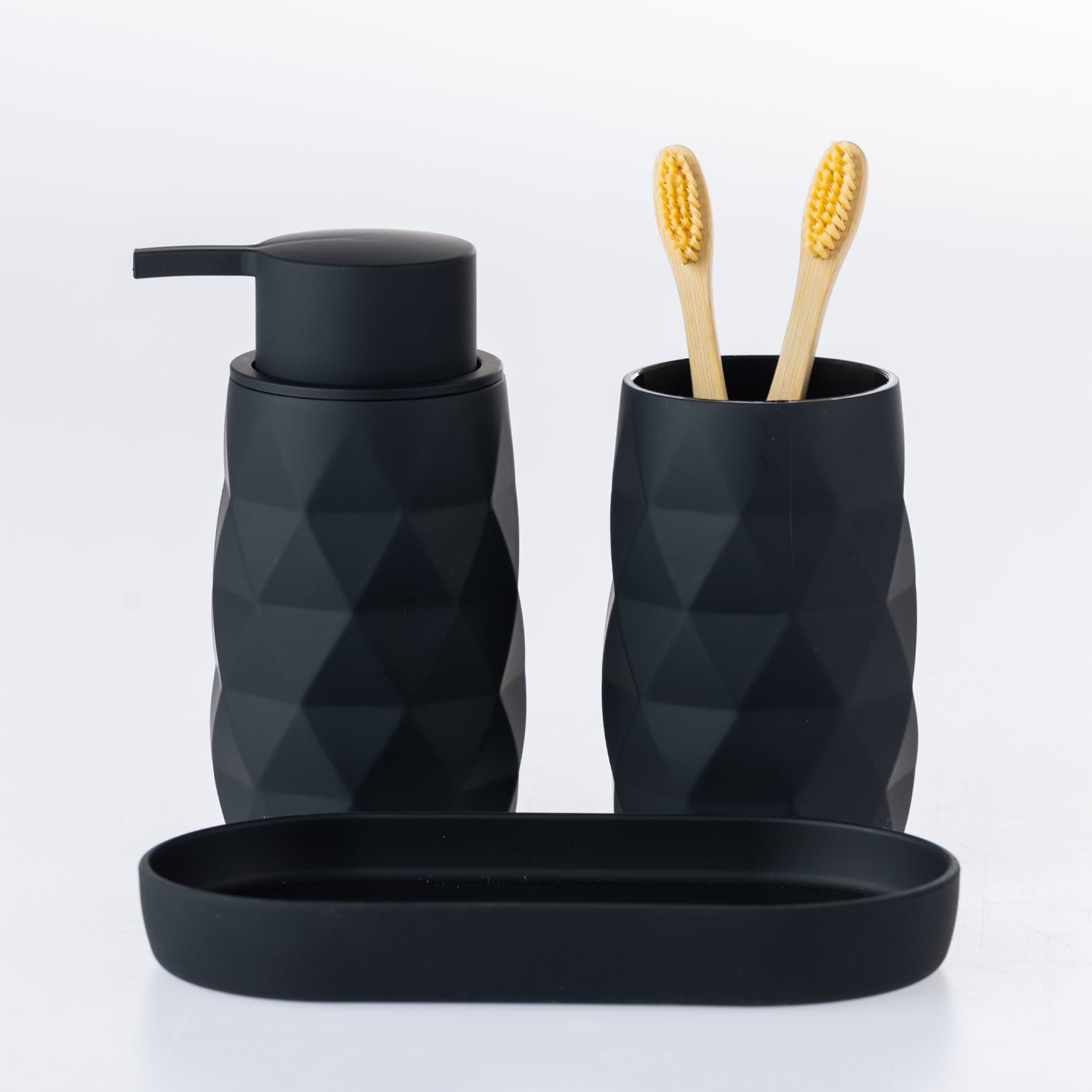 Terry 3-piece black bathroom accessory set featuring a soap dispenser, toothbrush tumbler with two bamboo toothbrushes, and a matching oval tray.