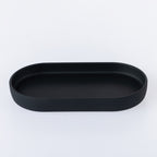 Black oval bathroom tray with a smooth matte finish, designed for organising soap dispensers, toothbrush holders, and other bathroom essentials.