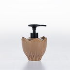 A natural ceramic soap dispenser with a black pump, shaped like a lotus flower, on a white background.