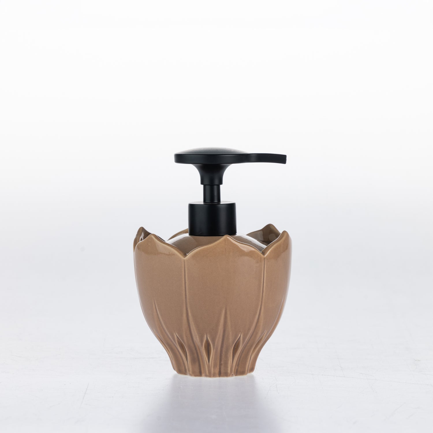 A natural ceramic soap dispenser with a black pump, shaped like a lotus flower, on a white background.