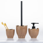 Three-piece ceramic bathroom set in a warm brown glaze, featuring a toothbrush holder with two yellow toothbrushes, a toilet brush with a black handle, and a pump dispenser with a black pump, all on a white background.