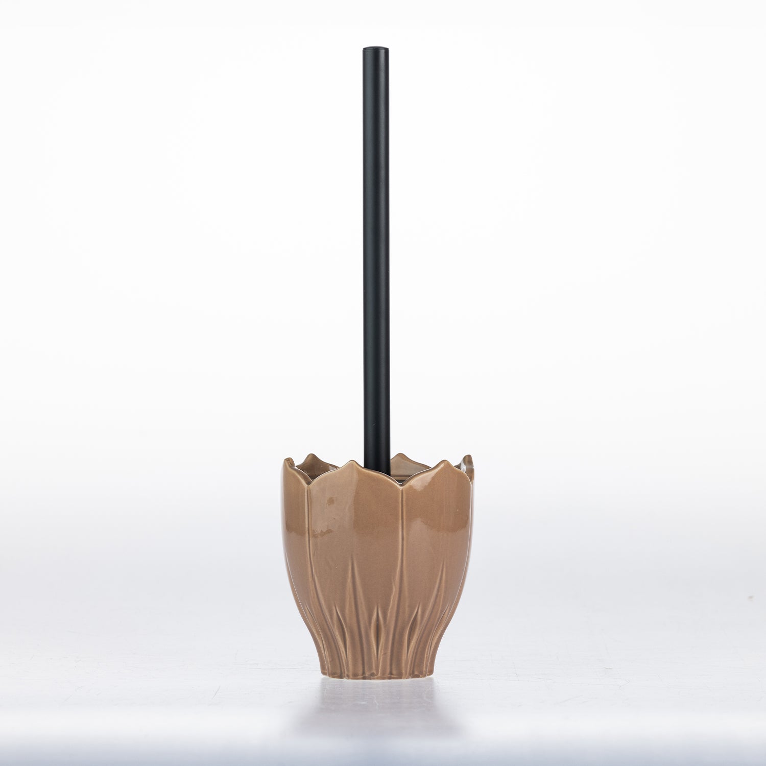 A ceramic toilet paper holder with a textured, lotus-petal-like base in a warm tan glaze, holding a black toilet paper stick, set against a clean white background.