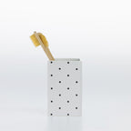 Design Republique Spotty Ceramic Tumbler in White styled with a toothbrush to show its use as a bathroom toothbrush holder.