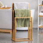A freestanding bamboo towel rack neatly displays soft towels in a bright, modern bathroom, combining natural style with practical everyday storage.