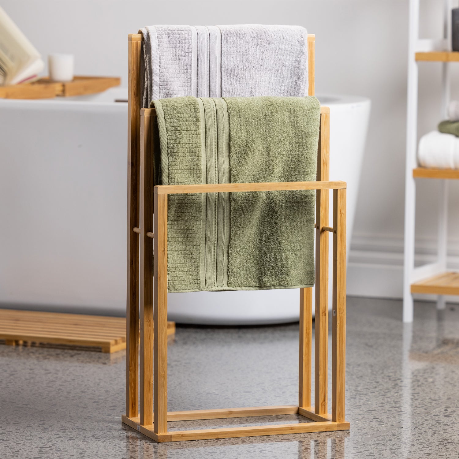 A freestanding bamboo towel rack neatly displays soft towels in a bright, modern bathroom, combining natural style with practical everyday storage.