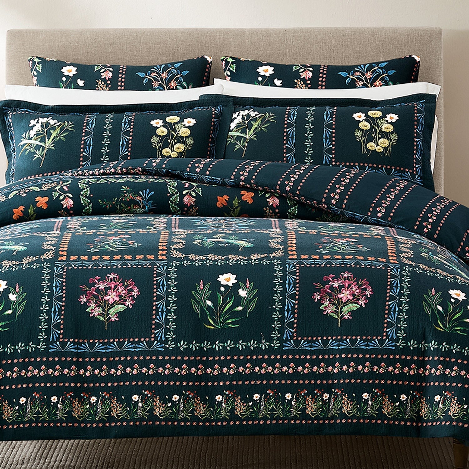 Floral patterned bedding set on a bed with a beige headboard.