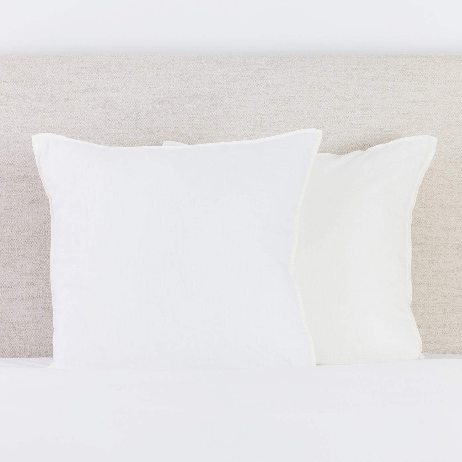 Coconut Milk linen look European pillowcases styled on a bed with a neutral fabric headboard.