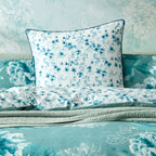 A styled bedding set featuring a blue floral pattern European pillow.