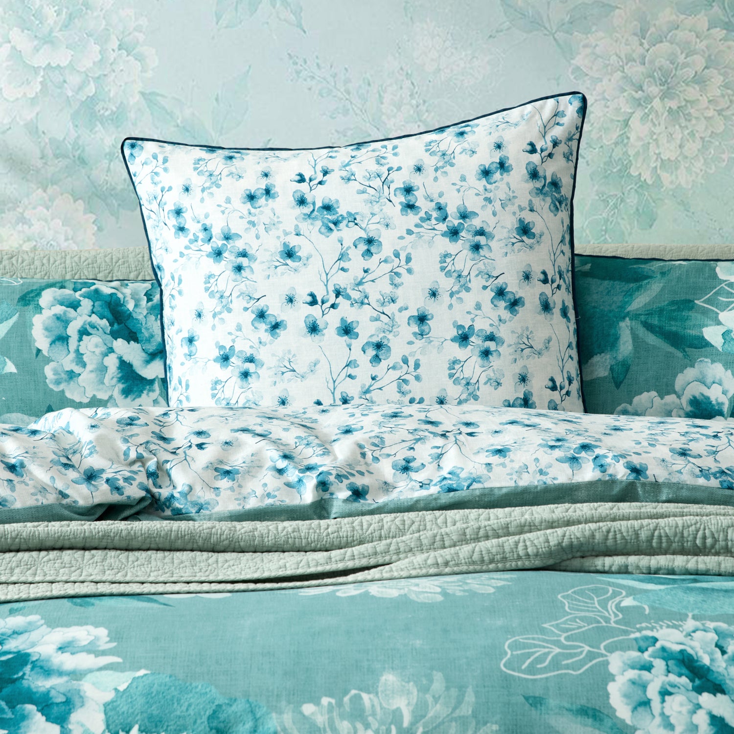 A styled bedding set featuring a blue floral pattern European pillow.