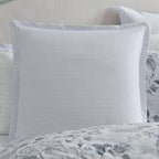 Styled view of the Private Collection Hydrangea 100% Cotton Euro Pillowcase on a bed, showcasing its subtle grey and white stripe design alongside coordinating floral bedding.