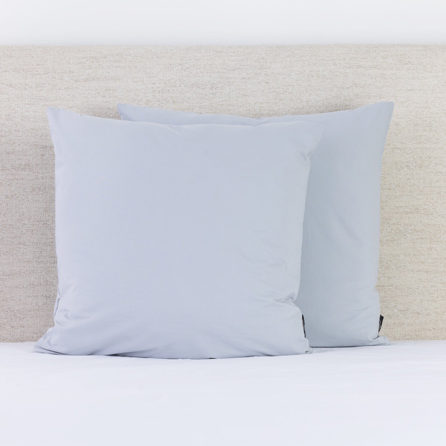 A pair of soft Mist European pillowcases adds a fresh, calming touch to a neatly styled bed.