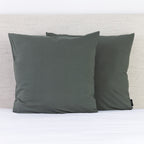 A pair of deep thyme green European pillowcases adds a rich, contemporary accent to a neatly styled bed.