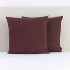 A pair of rich hazelnut European pillowcases adds a warm, sophisticated accent to a neatly styled bed.