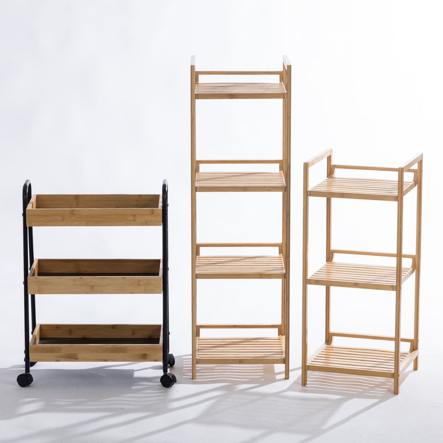 Three versatile bamboo storage pieces—a rolling trolley, a four-tier shelf, and a three-tier shelf—are displayed side by side, offering coordinated natural storage solutions for every room in the home.