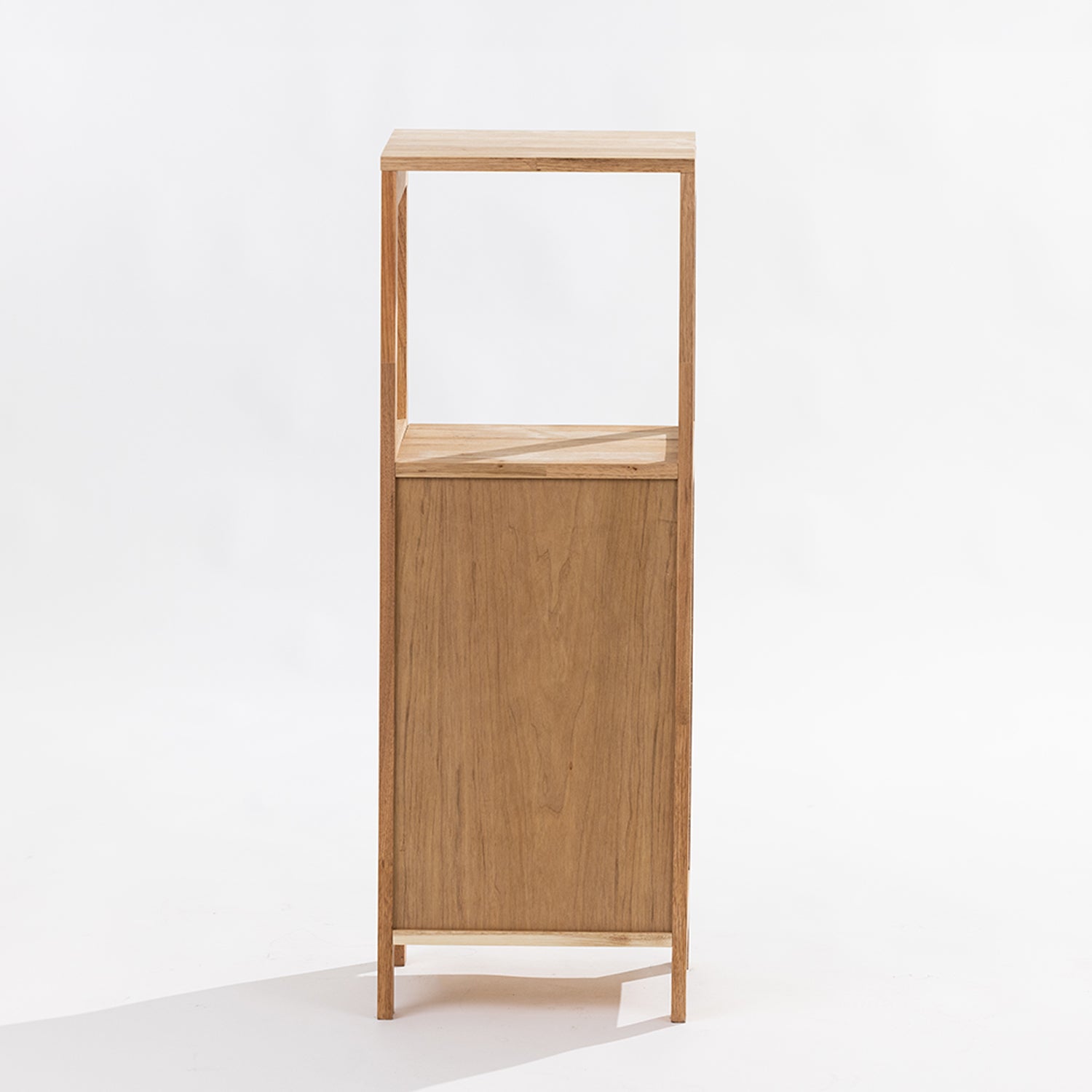 A minimalist two-tier wooden cabinet with an open upper shelf and a single lower door, crafted from light oak wood with a visible grain, set against a plain white background. Back View