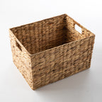 Natural water hyacinth woven cube storage basket with integrated cut-out handles on both sides.