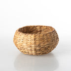 Round natural water hyacinth basket with wrapped side handles and a woven textured finish.