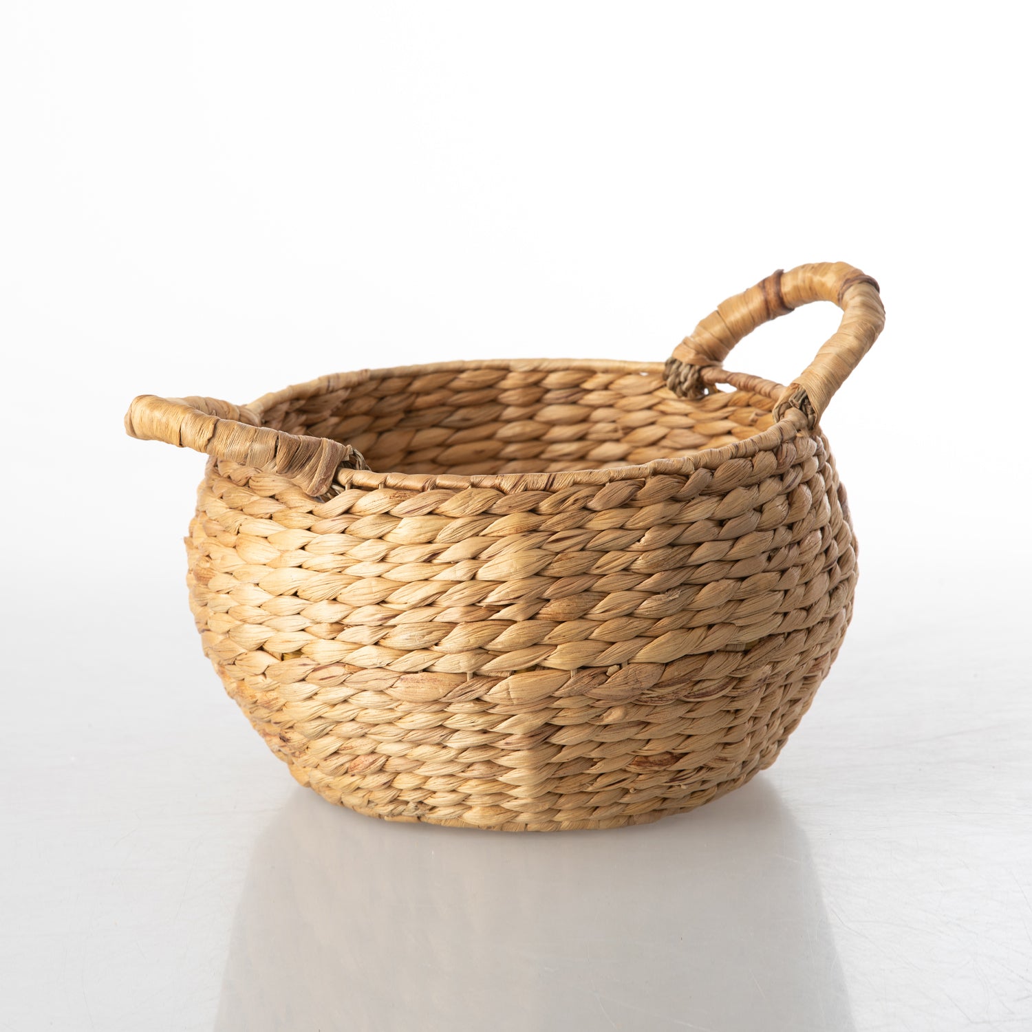 Round natural water hyacinth basket with a woven textured finish and handle-free design.