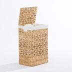 Natural woven laundry hamper with a hinged lid and white fabric lining, shown open against a white background.