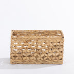 Natural woven rectangular storage basket with an open decorative weave, shown at a slight angle against a white background.
