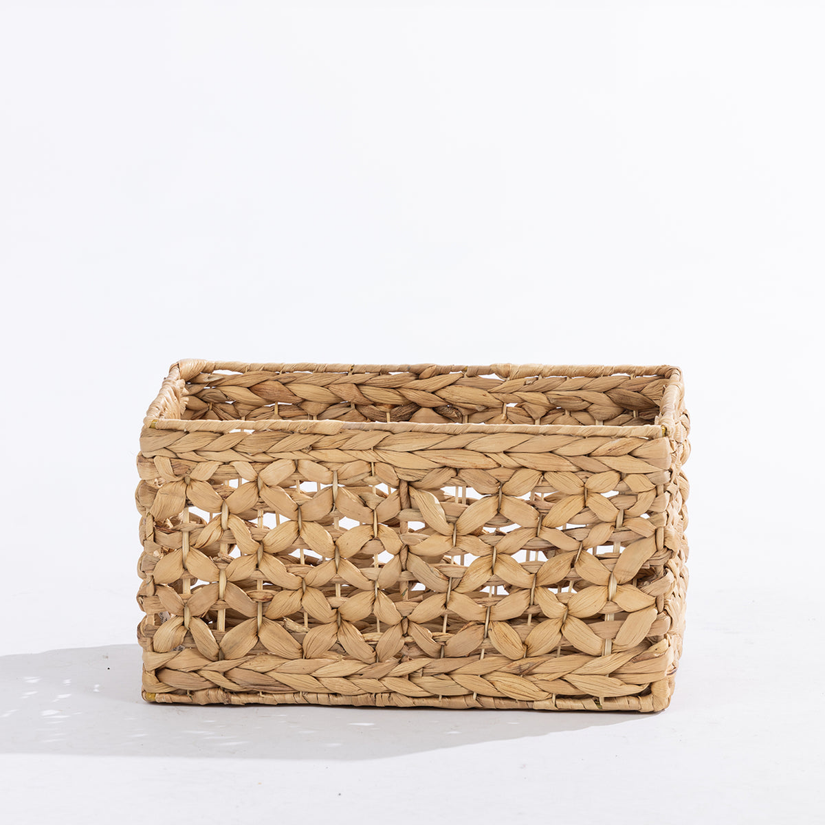 Natural woven rectangular storage basket with an open decorative weave, shown at a slight angle against a white background.
