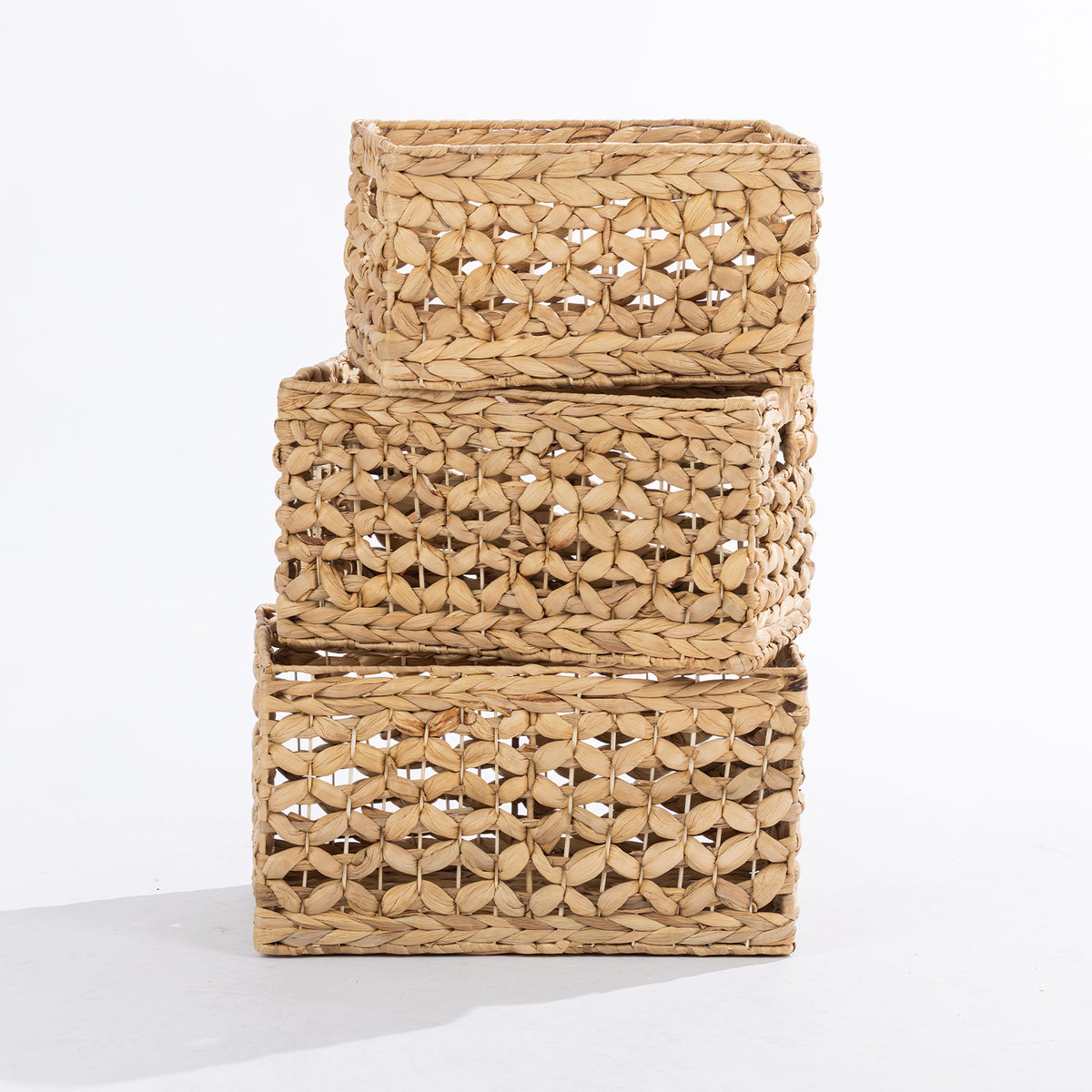 Three natural woven rectangular storage baskets in small, medium and large sizes, stacked together against a white background.