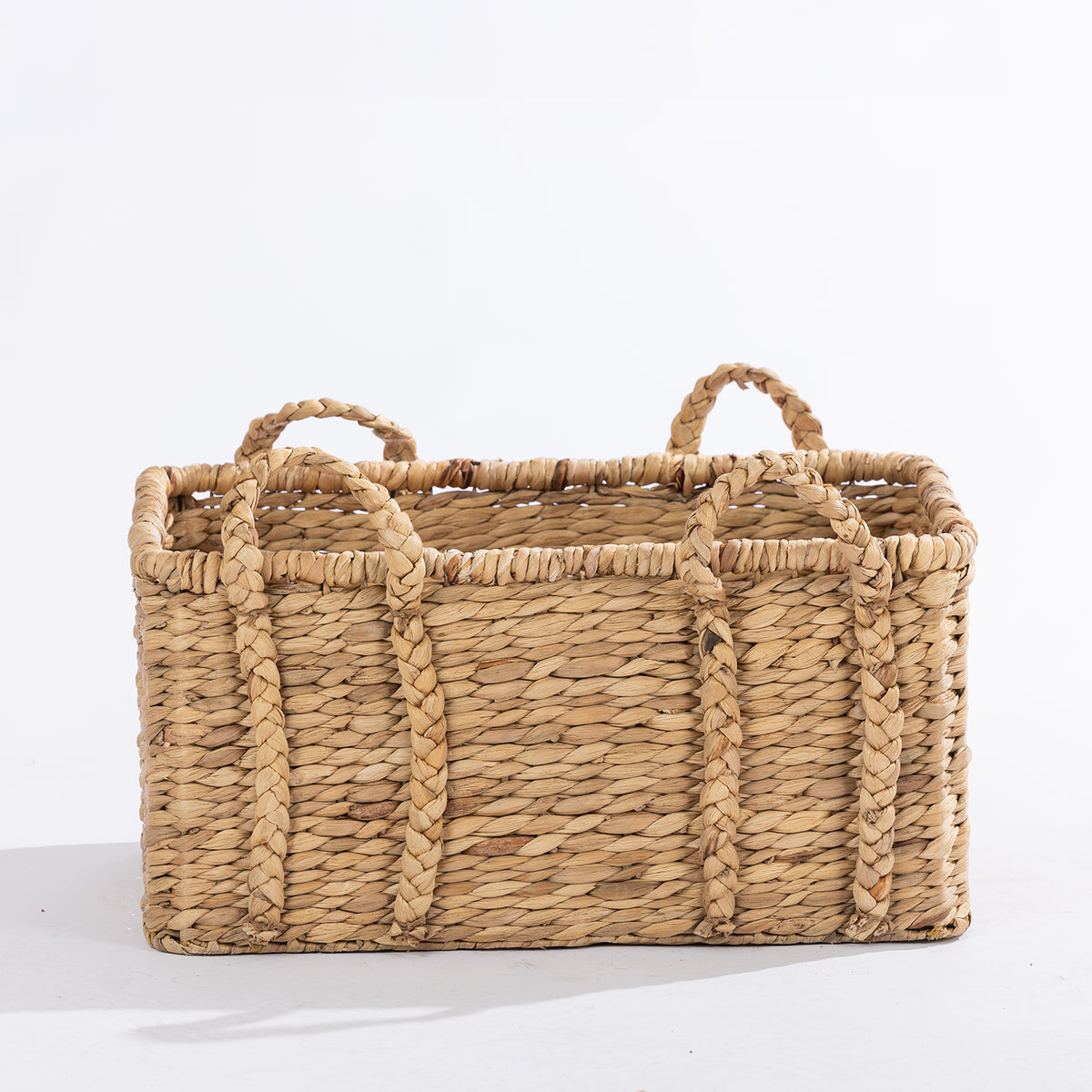 Large natural woven rectangular basket with braided handles, shown against a white background.