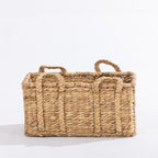 Medium natural woven rectangular basket with braided handles, shown against a white background.