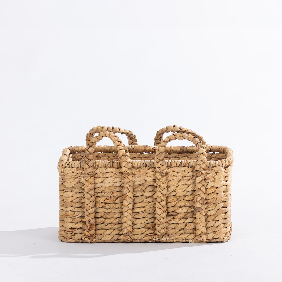 Small natural woven rectangular basket with braided handles, shown against a white background.