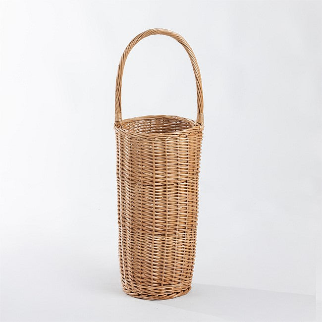 A tall, cylindrical woven wicker basket with a single arched handle, shown on a clean white studio background.