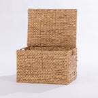 A rectangular woven storage basket with a hinged lid, made from natural tan  or wicker, shown open on a white studio background.