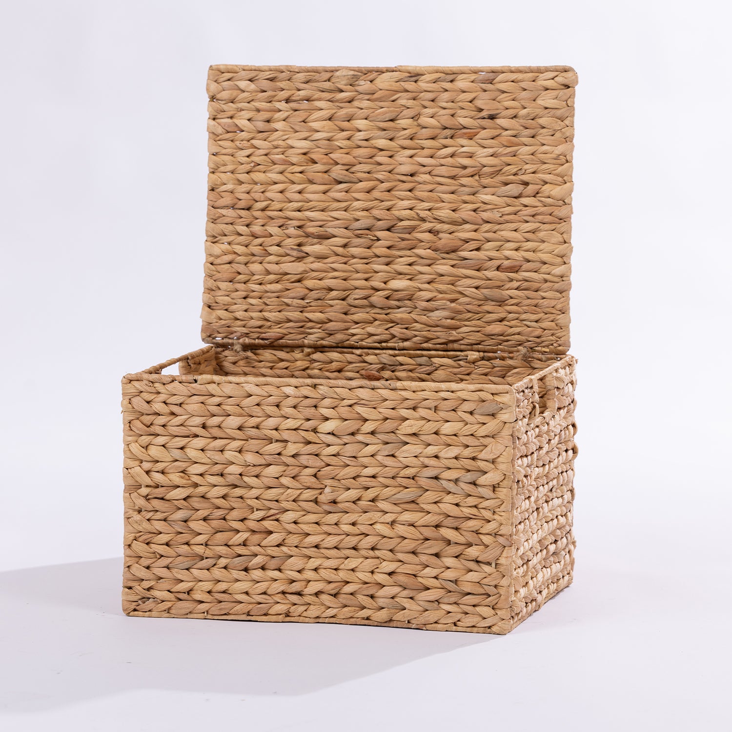 A rectangular woven storage basket with a hinged lid, made from natural tan  or wicker, shown open on a white studio background.