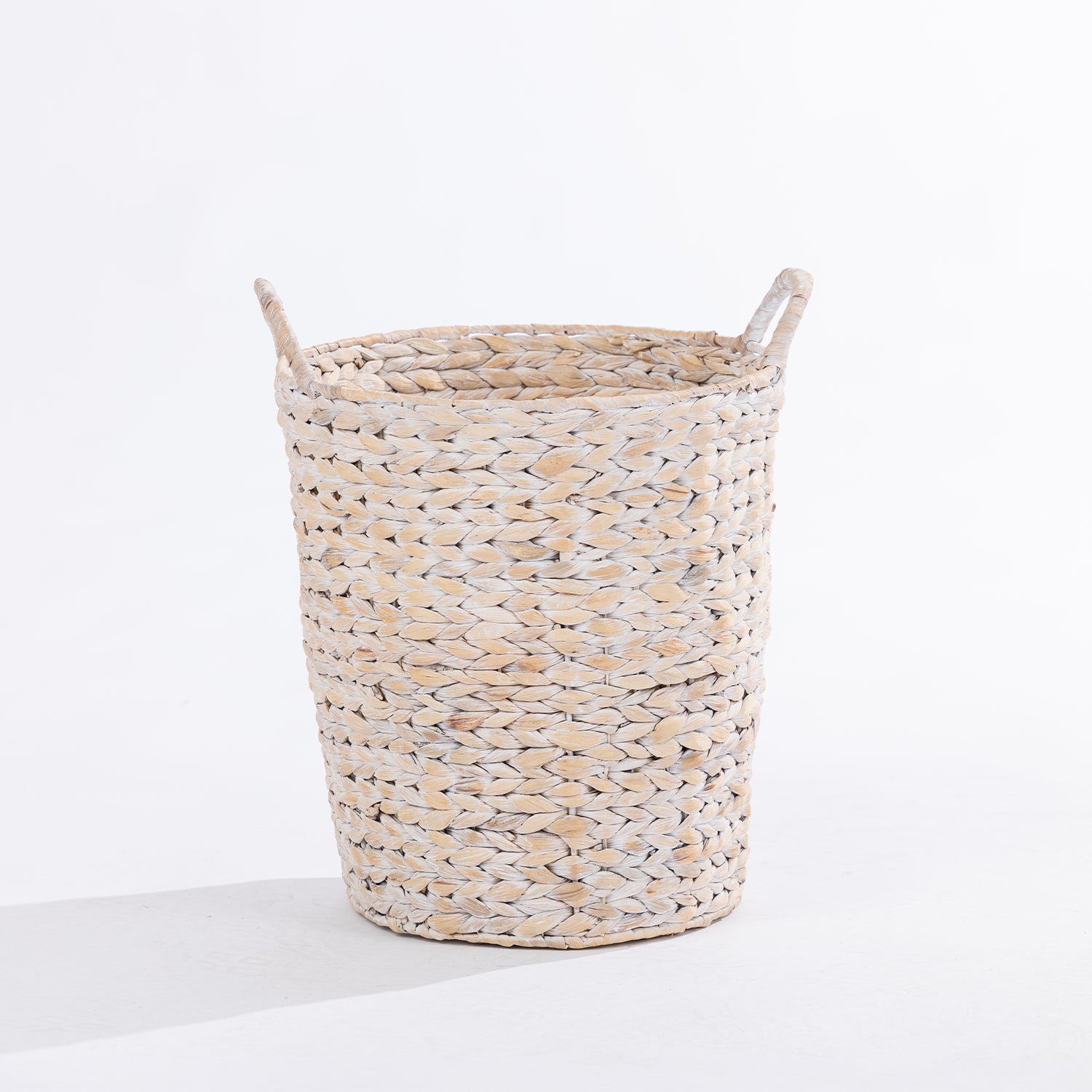 A natural woven laundry basket with two loop handles, shown on a clean white background.