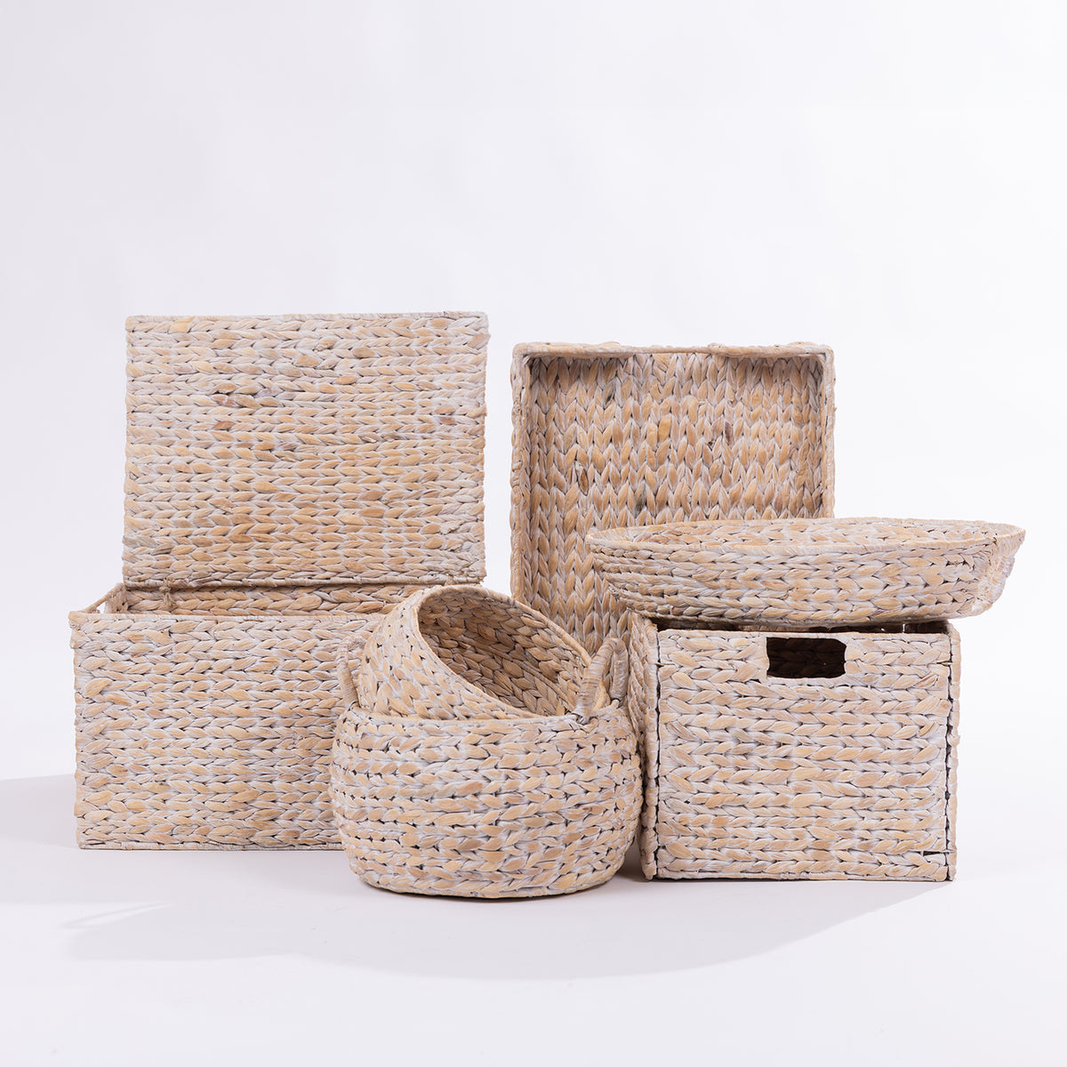 A set of natural woven seagrass storage baskets and boxes in various sizes, arranged on a clean white studio background.