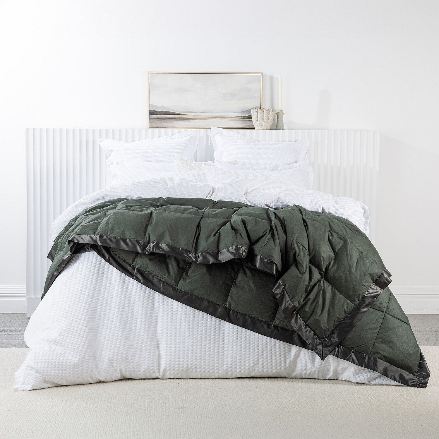 A luxuriously soft feather and down blanket in a rich forest green tone, finished with elegant satin trim for a warm and sophisticated bedroom look.