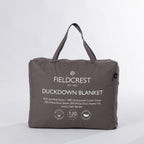 A premium feather and down blanket neatly packed in a soft carry bag, featuring a luxurious cotton cover, satin border, and plush duck down fill for lightweight warmth.
