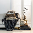A beautifully styled living room scene featuring layered faux-fur throws, blankets and cushions in rich neutral and animal-inspired tones, creating a warm and luxurious atmosphere.