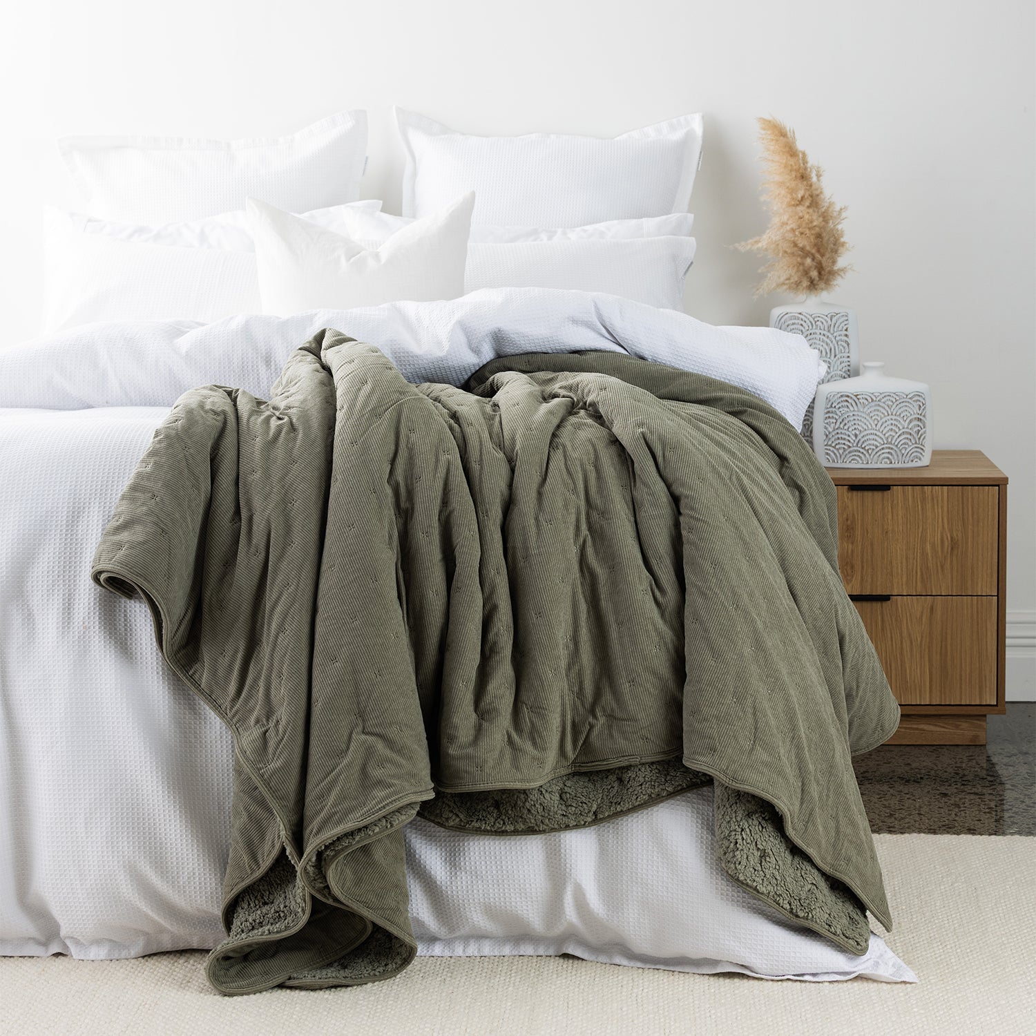 Green blanket styled on bed