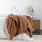 Rust blanket styled on bed